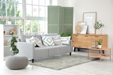 Interior of living room with sofa, table and green folding screen