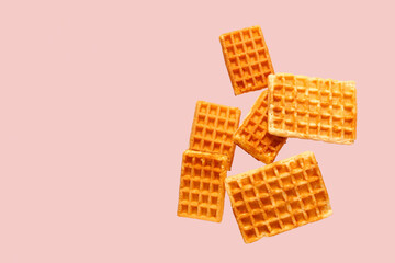 Falling waffles on pink background