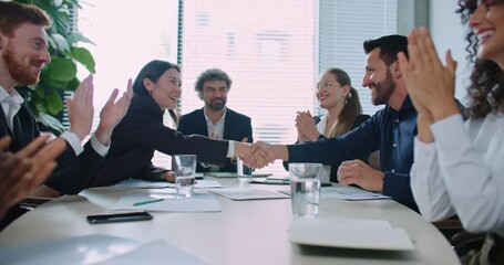 Ending of team meeting in business company. Diverse people in official clothing. Everyone shaking hands, clapping. Positive ending to discussion. Celebrating positive development. Concept of success - Powered by Adobe