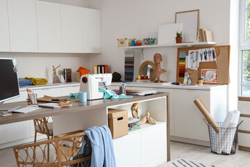 Interior of fashion designer's studio with workplace and sewing supplies