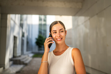 Portrait of young woman talk on mobile phone in front building