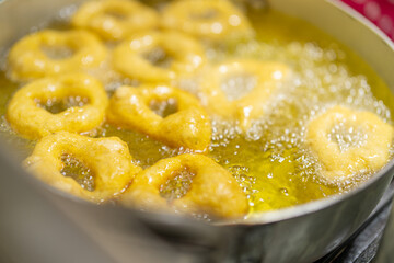 Delicious picarones being deep fried in a pan