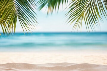 Fototapeta premium Beautiful summer background with palm leaves, sandy beach, and blurred sea view, ideal for vacation themes. Captured with a Nikon D850.