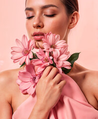 Portrait of a serene woman embracing pink flowers, symbolizing beauty, strength, and hope in the fight against breast cancer.