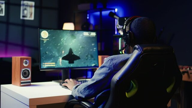 Heartbroken gamer dejected after losing in online multiplayer videogame, being defeated by rivals. Man putting hands on head in frustration after seeing game over screen on gaming pc monitor, camera B