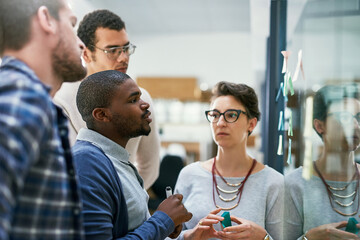 Office, employee and teamwork on glass wall for strategy with meeting, collaboration and planning....