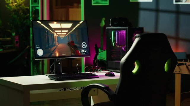 Neon lit components on opened gaming PC device next to keyboard, speakers, wired mouse and headphones in empty apartment. Computer in home with colorful gpu and cpu parts, panning shot
