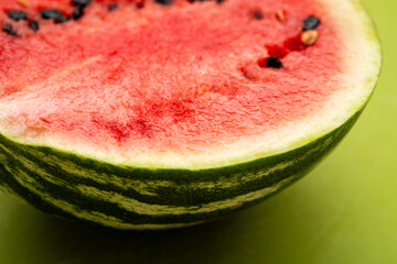 Freshly Cut Organic Watermelon with Juicy Red Flesh and Black Seeds on a Green Background