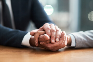 Business people, holding hands and closeup in office for empathy, support and grief counseling in...