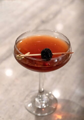 Manhattan cocktail with cherry on a toothpick