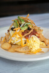 Breakfast hash with eggs potatoes cheese salsa avocado tortilla strips