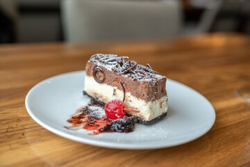 Chocolate mousse cheesecake dessert on a white plate with copy space