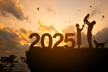 New year 2025 concept.Silhouette of Happy family celebrating On a cliff with a sea view over sunset...