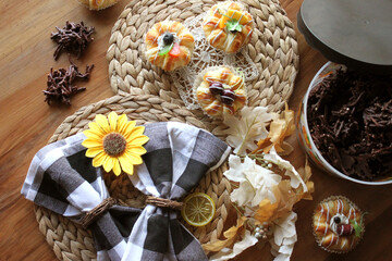 Homemade Chocolate Stick Candy with Sparkling Sugar in a Festive Halloween Bucket with Light Pastries on Wicker Place Mats with Sunflower and Buffalo Check Decor