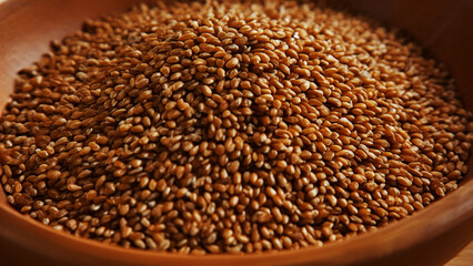 Obraz premium Close-Up of Brown Seeds in a Wooden Bowl