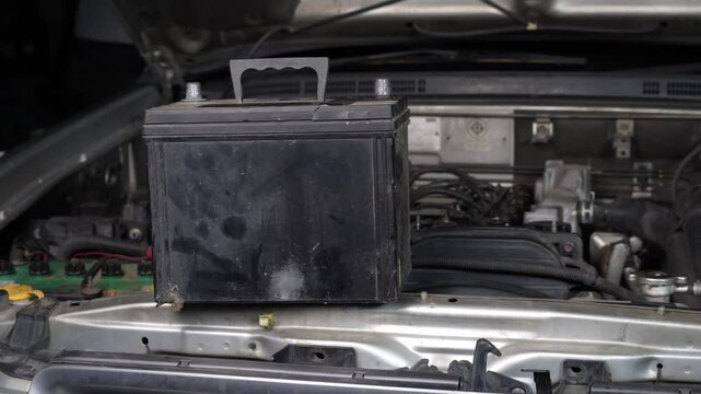 Closeup of a car battery on the hood.The battery is expire no longer working.