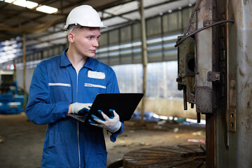 technician or engineer working on laptop computer in the factory