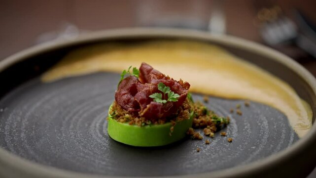 Avocado with stuffed tuna decorated on a rotating platein the kitchen. Close-up view