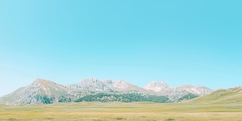 Fototapeta premium Mountain Range Landscape with Grassy Meadow and Clear Blue Sky
