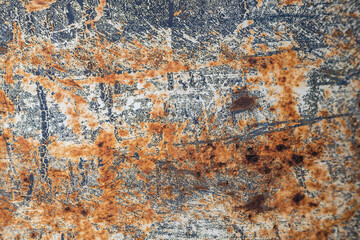 A rusty metal surface with a few spots of paint.