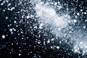 Obraz premium Explosion of snow falling down from sky or roof, heavy big small size snows. Freeze shot on black background isolated. Fluffy White snowflakes splash explode cloud up in mid air storm. Generative Ai