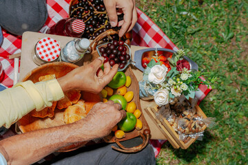 Son sharing a picnic day with his parents. People sipping. Happy Latino family.