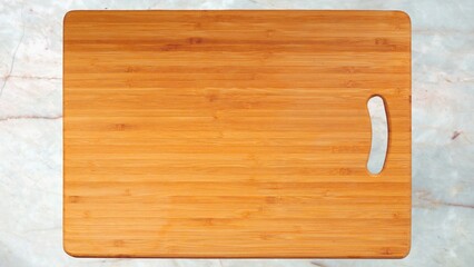 Wooden cutting board on marble counter.