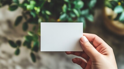 Hand Holding an Empty Blank White Business Card Mockup, Ideal for Advertisement and Branding Purposes. 