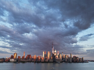 NYC aerial view, New York City Skyline with dramatic sky. Panoramic drone view on Manhattan in NY. Sunset in NYC. New York City Midtown skyline view at dusk with dark clouds.