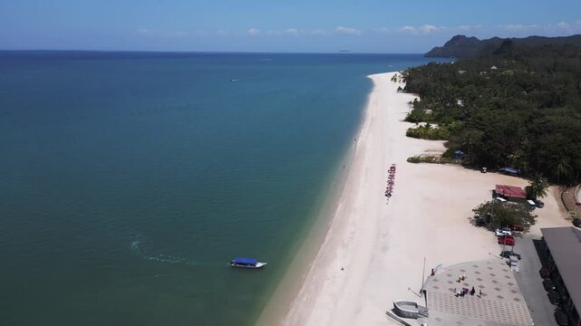 parasols on Sand beach Rekreasi Kastam with turquoise water on Langkawi. Stunning aerial view flight drone shot footage from above