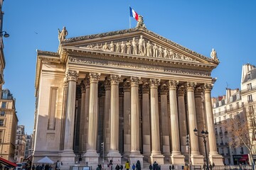 Naklejka premium The building is an ancient Greek style temple with columns and statues on top