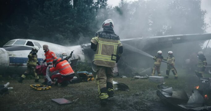 Follow Footage of a Running Firefighter at a Plane Crash Site: Emergency Responders and Medics Working at the Scene of the Accident, Extinguishing Fire and Providing Medical Assistance to Survivors