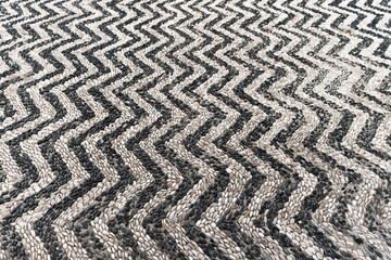 Mosaic ground pavement with striped pattern of black and white pebble stones