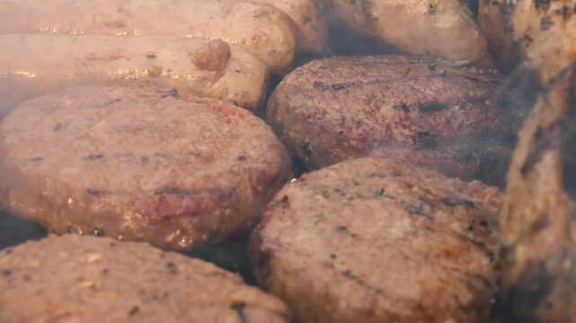 Beef burgers cooking on charcoal barbecue 