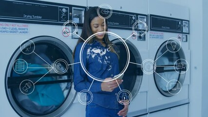 Digital communication icons animation over woman using smartphone in laundromat - Powered by Adobe
