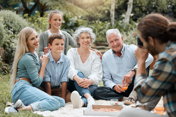 Photograph, picnic and smile with family outdoor together for bonding, fun or love in summer. Food, group picture and nature with happy senior people, parents and children in park for wellness