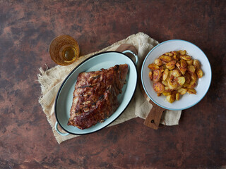 top view of food on a rustic table: delicious, juicy pork ribs and baked potatoes