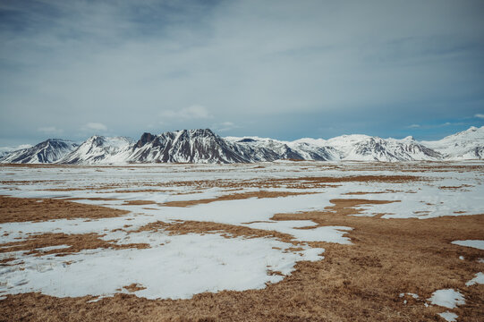 Snow-capped mountains with brown gras at Ytri Tunga