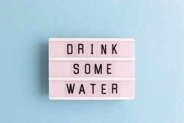 Drink some water. White lightbox with letters on a blue background.