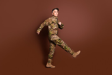 Full body photo of attractive mature woman army soldier walk march wear military uniform isolated on brown color background