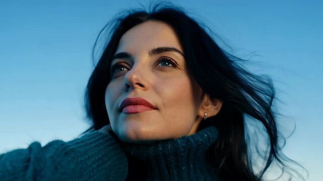 Captivating woman gazing up at the expansive blue sky