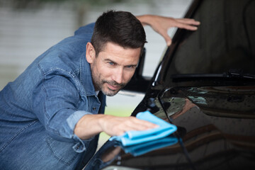 man worker polishing car on a car wash