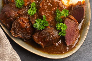 Stewed goose stomach.  Traditional Polish meat on a dark background.