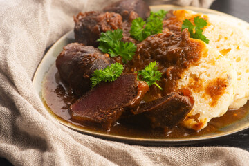 Stewed goose stomach.  Traditional Polish meat on a dark background.