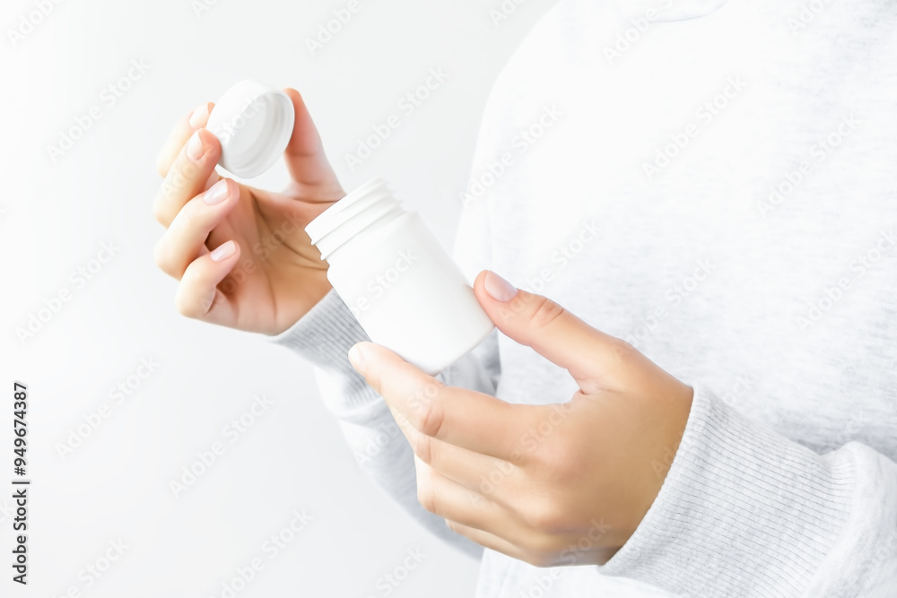 Wall mural woman opens plastic bottle with pills