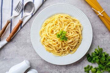 Boiled spaghetti , cooked spaghetti , boiled spaghetti in a white ceramic plate on grey cement background