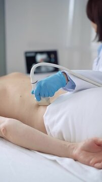 Doctor woman with blue medical gloves performing ultrasound examination on patient's back