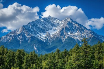 Obraz premium Majestic Snow-Capped Mountain Peak Against a Blue Sky with White Puffy Clouds and a Foreground of Green Trees