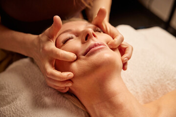 Mature Woman Relaxing During Face Massage in a Spa