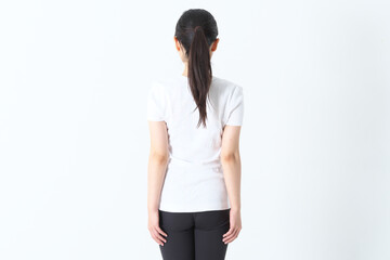 後ろ姿のTシャスにスパッツ姿の20代の女性